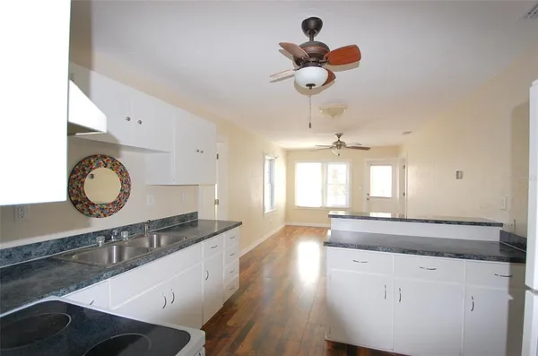 a kitchen with kitchen island granite countertop a sink a stove and a window