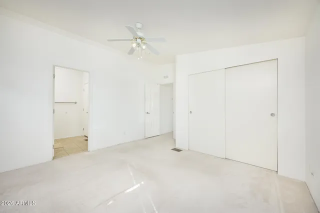an empty room with a chandelier fan