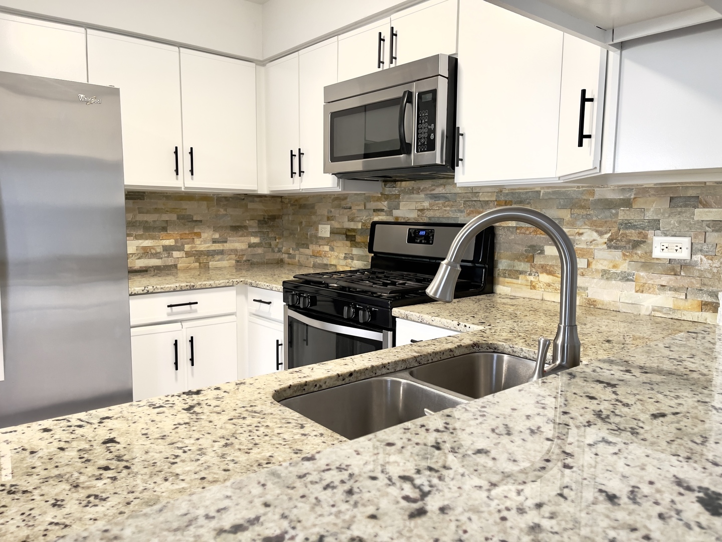4480 Opal Drive Hoffman Estates, IL 60192 - Photo 9 of 18 a kitchen with granite countertop a sink and a stove top oven with wooden floor