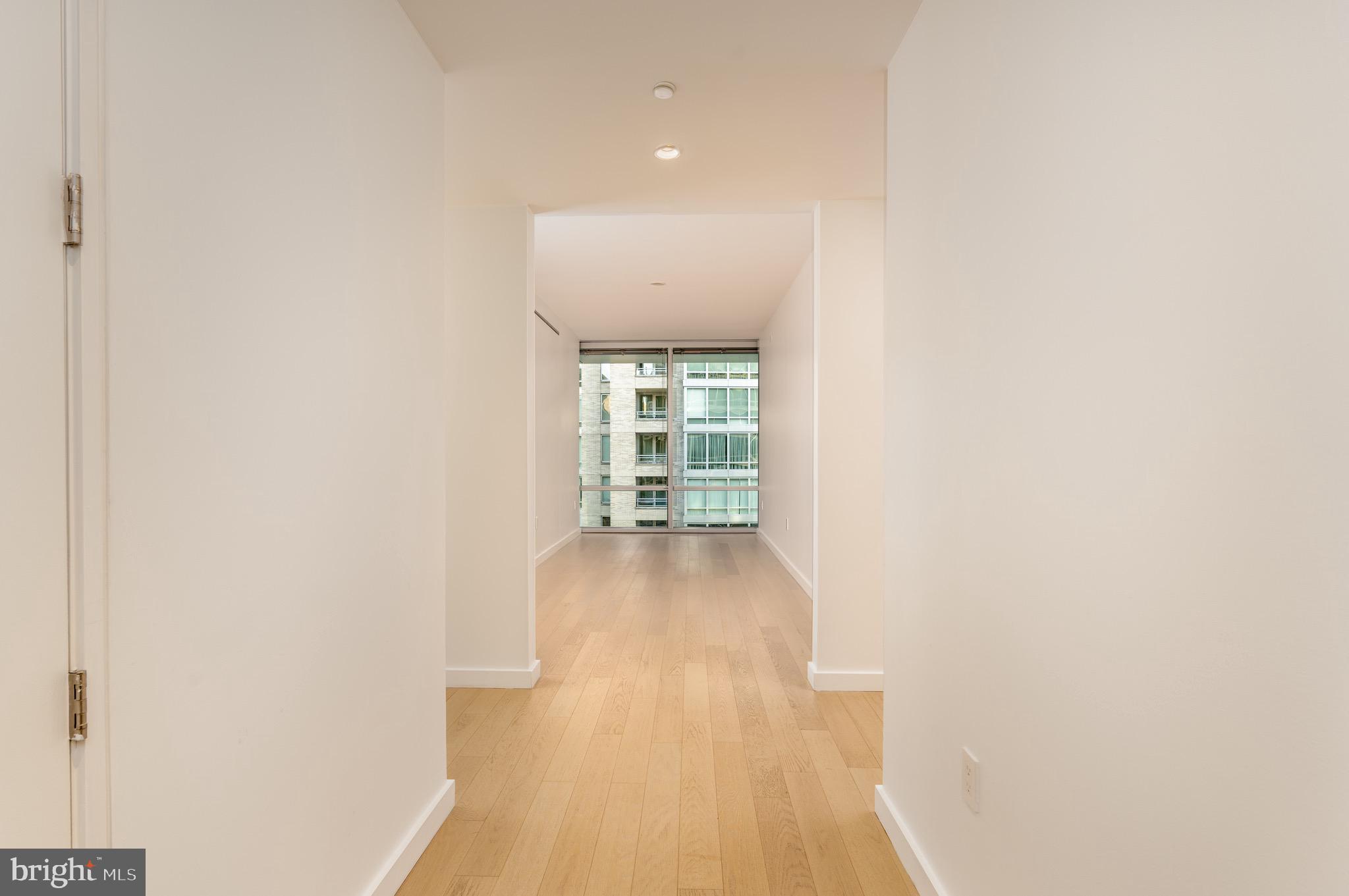 1110 23rd Street Northwest, Unit 505 Washington, DC 20037 - Photo 11 of 25 a view of an empty room with wooden floor and a window