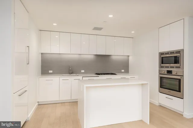 a kitchen with stainless steel appliances a stove microwave and refrigerator