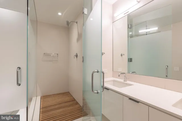 a bathroom with a double vanity sink a mirror and a shower