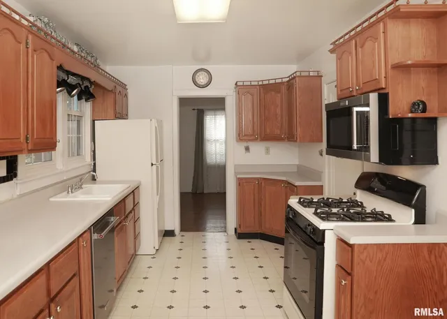 a kitchen with stainless steel appliances a stove a sink a refrigerator and cabinets