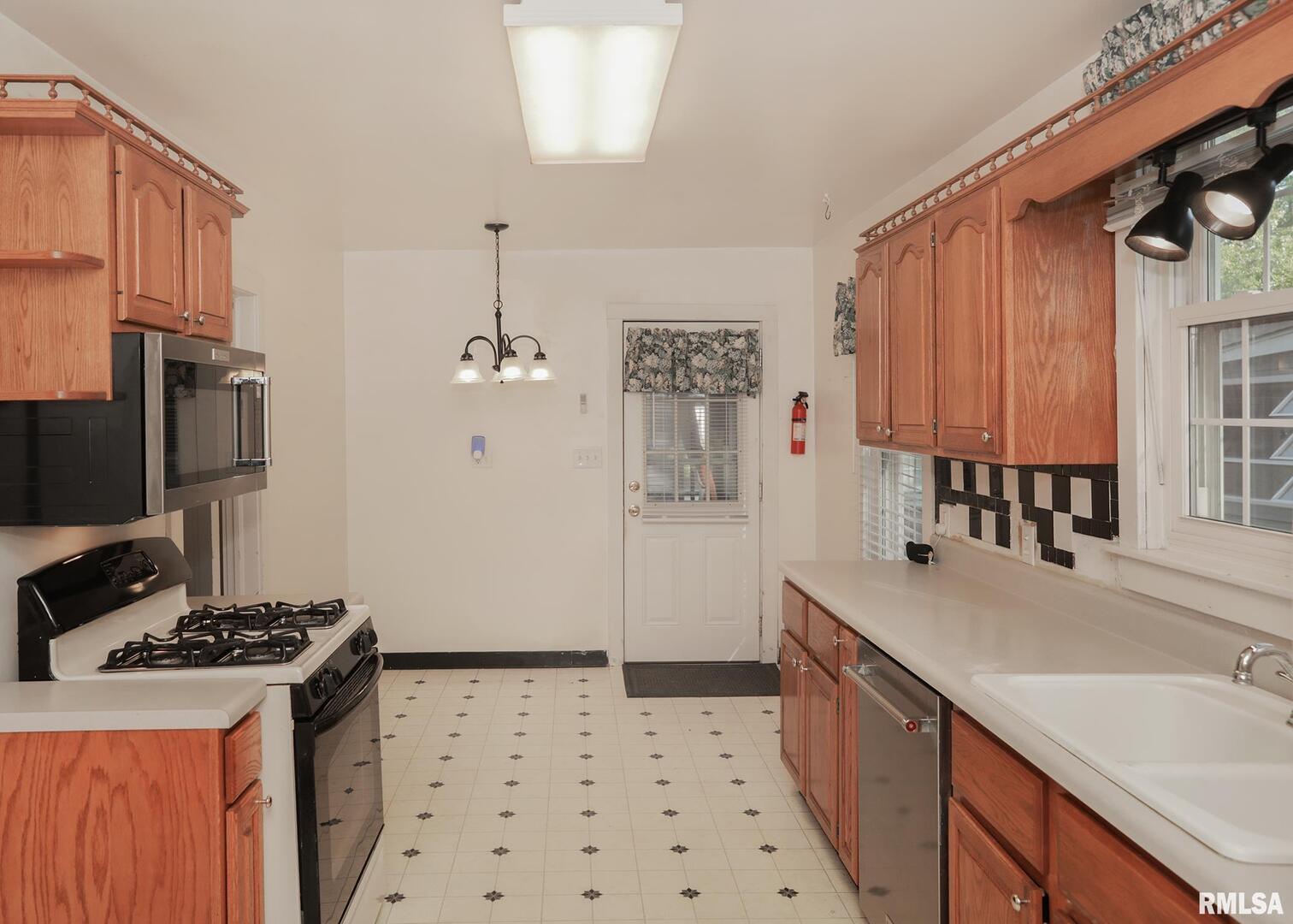 421 10th Street, Unit A Silvis, IL 61282 - Photo 14 of 37 a kitchen with granite countertop a sink stove and refrigerator