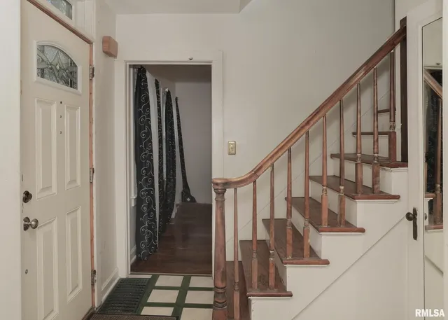 a view of staircase with lots of frames on wall and door