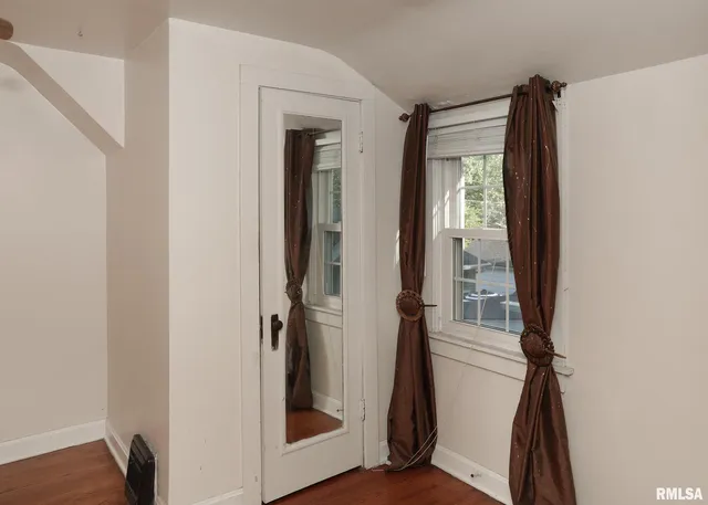 a view of a hallway with wooden floor and entryway