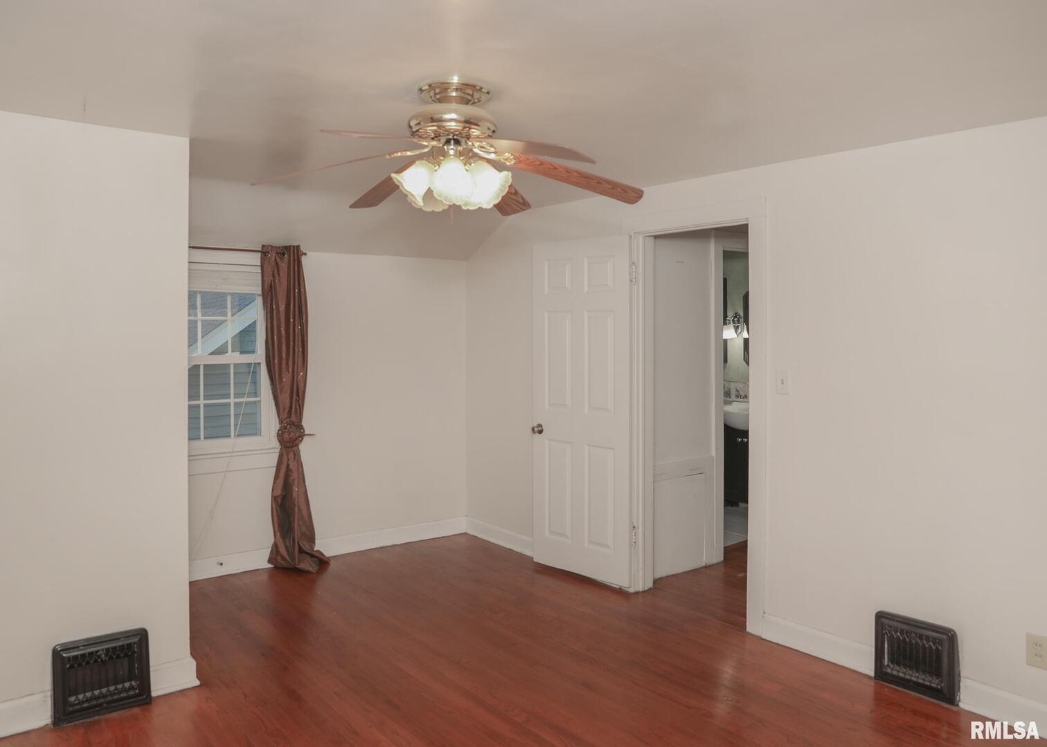 421 10th Street, Unit A Silvis, IL 61282 - Photo 22 of 37 an empty room with wooden floor and chandelier fan