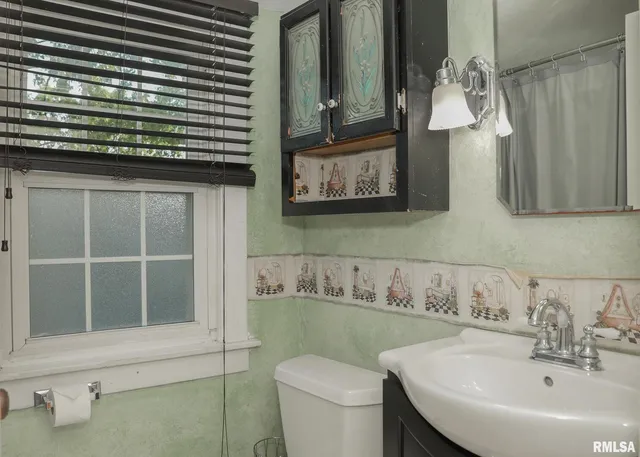 a bathroom with a sink a toilet and mirror