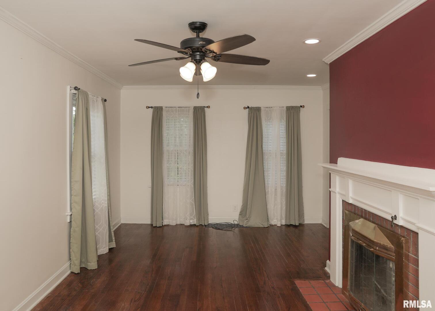 421 10th Street, Unit A Silvis, IL 61282 - Photo 8 of 37 an empty room with wooden floor fireplace and windows
