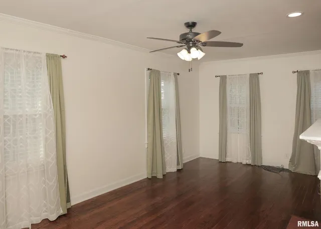 a view of a livingroom with wooden floor and a ceiling fan