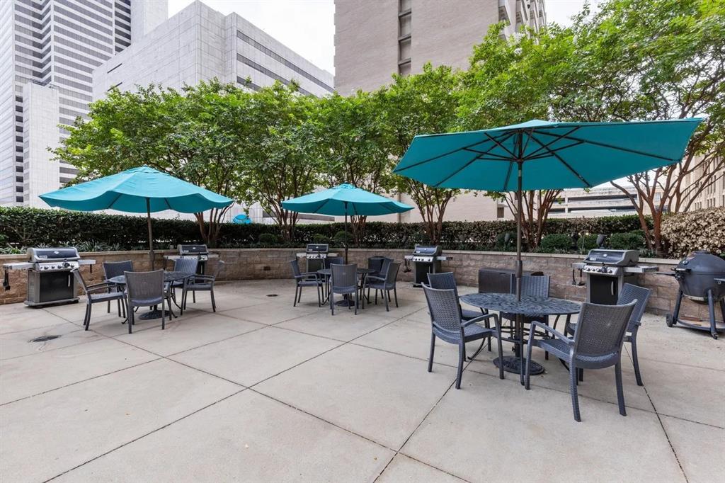 1200 Main Street, Unit 902 Dallas, TX 75202 - Photo 4 of 13 a view of patio with chairs and table under an umbrella with a barbeque