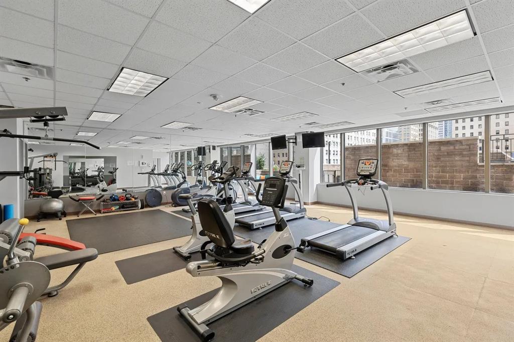 1200 Main Street, Unit 902 Dallas, TX 75202 - Photo 7 of 13 a room with gym equipment and a table