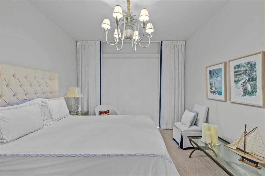 1020 Sunset Point Road, Unit 510 Clearwater, FL 33755 - Photo 15 of 44 a bed room with a bed mirror and a chandelier