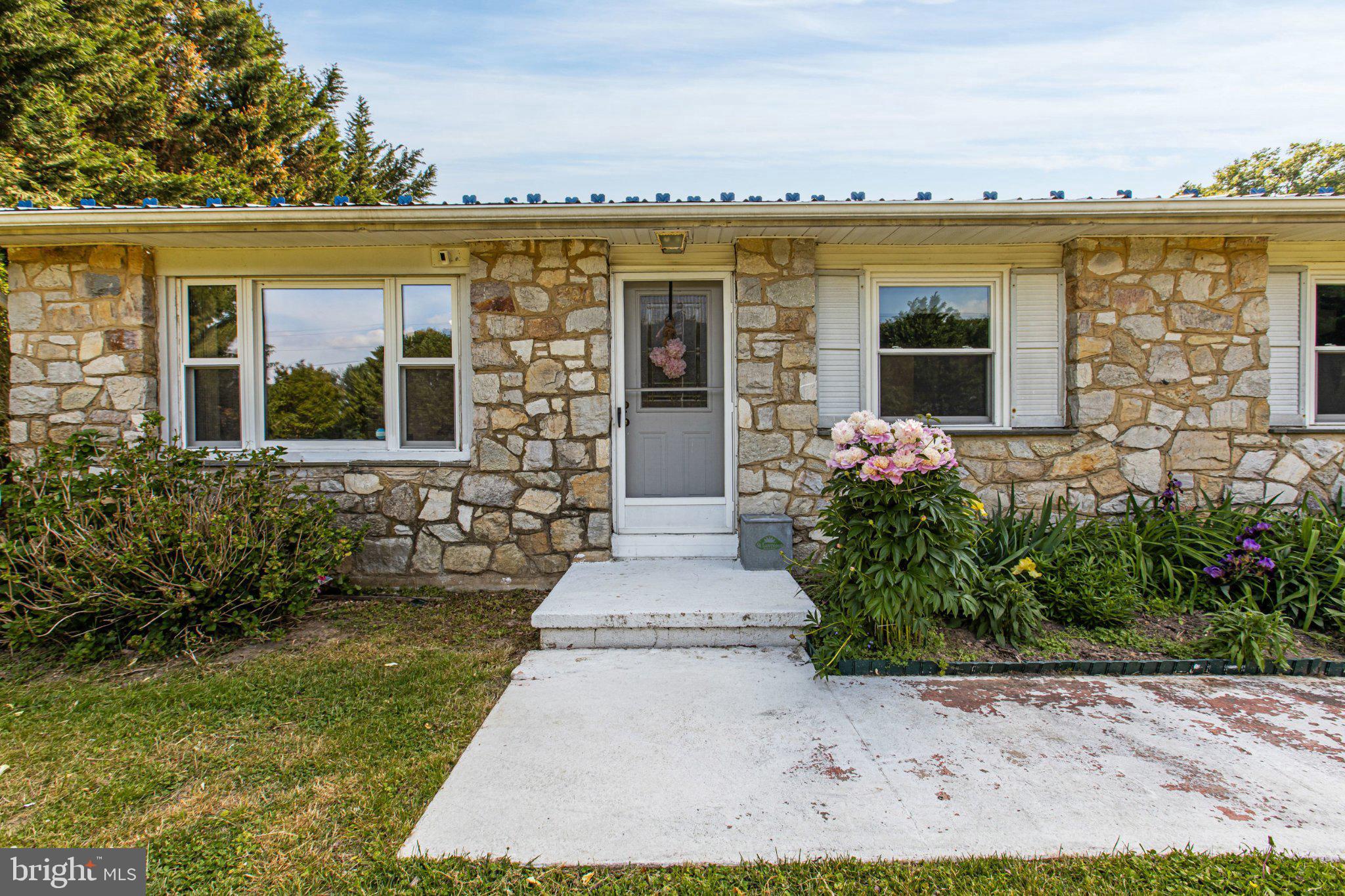 310 Dogtown Road Townsend, DE 19734 - Photo 4 of 43 Charming stone facade with vibrant blooms.