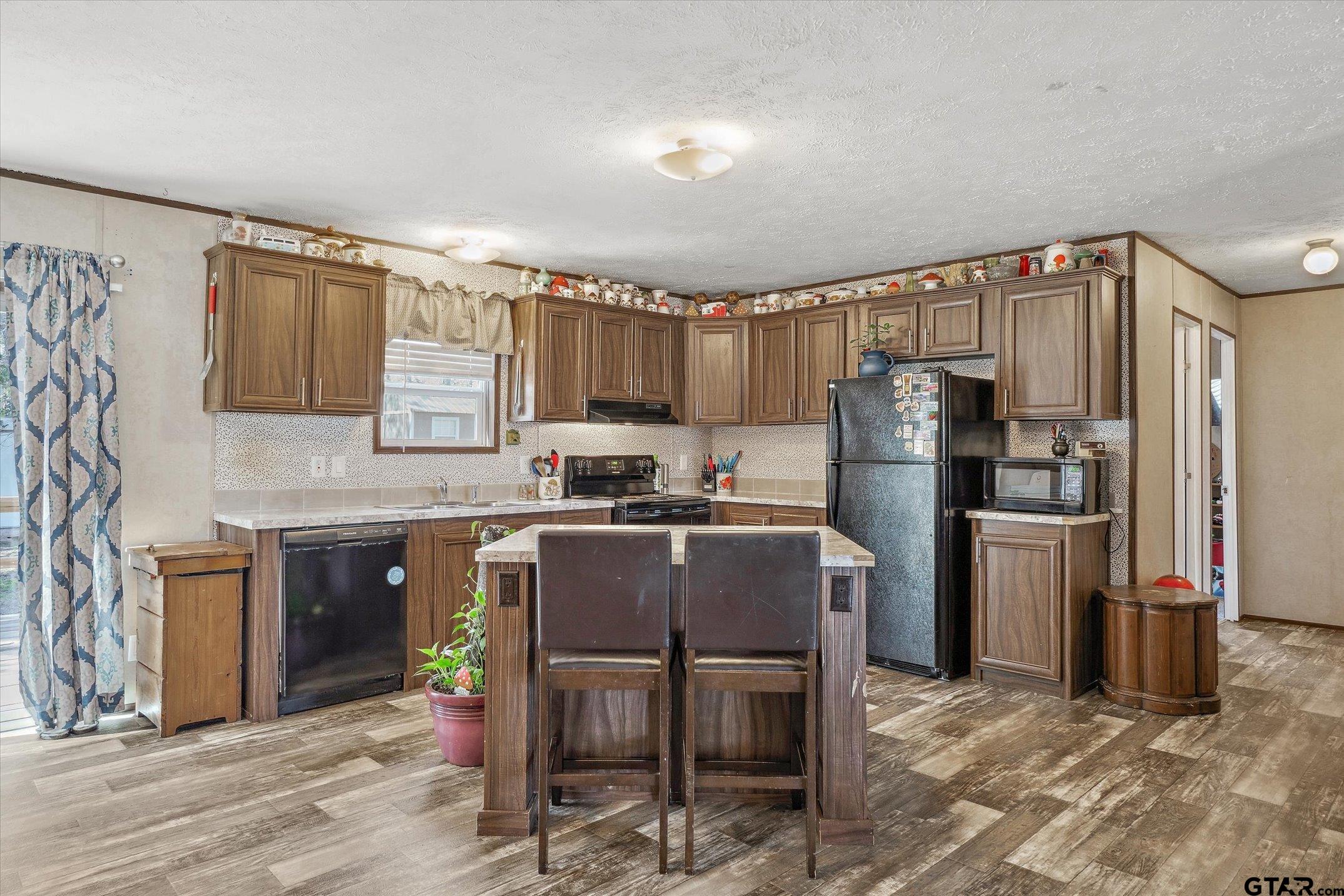 129 Elm Drive Murchison, TX 75778 - Photo 27 of 34 a kitchen with granite countertop a refrigerator stove top oven and sink