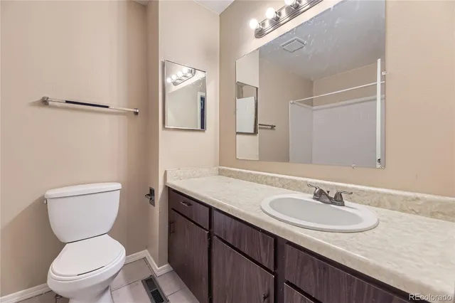 a bathroom with a granite countertop sink toilet and a mirror