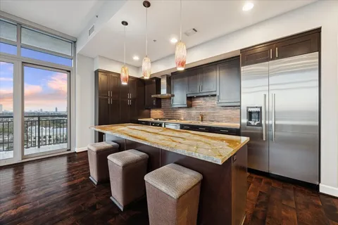 a kitchen with stainless steel appliances granite countertop a sink a stove and a refrigerator
