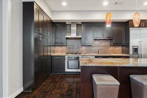 a large kitchen with stainless steel appliances granite countertop a sink and a stove