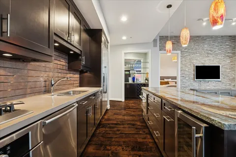 a kitchen with stainless steel appliances granite countertop a sink a stove and a refrigerator