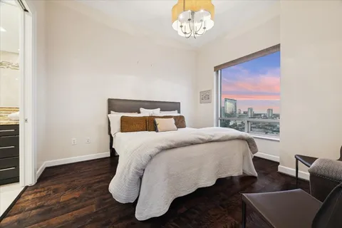 a bedroom with a bed mirror and window
