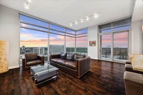 a view of empty room with wooden floor and floor to ceiling window