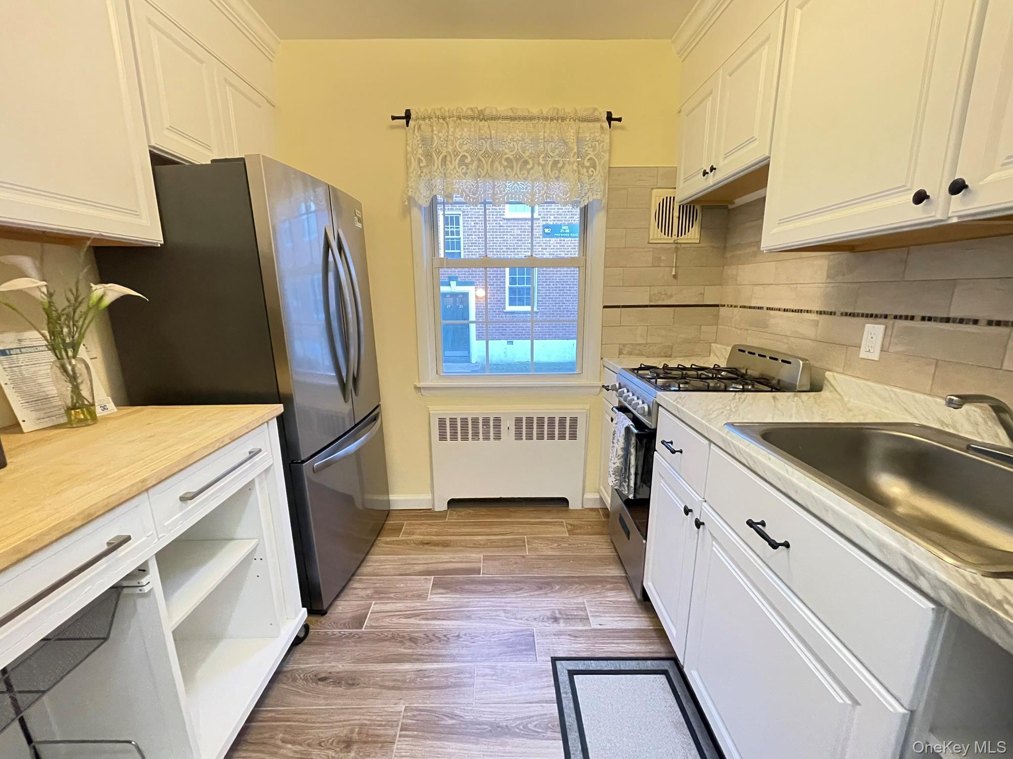 180 Pinewood Road, Unit 11 Hartsdale, NY 10530 - Photo 2 of 13 a kitchen with stainless steel appliances a sink stove and cabinets