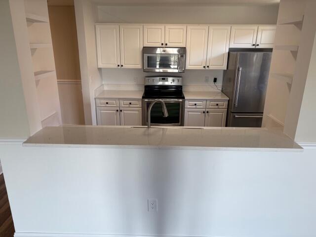 1200 Town Center Drive, Unit 427 Jupiter, FL 33458 - Photo 9 of 33 a kitchen with stainless steel appliances a refrigerator stove and cabinets