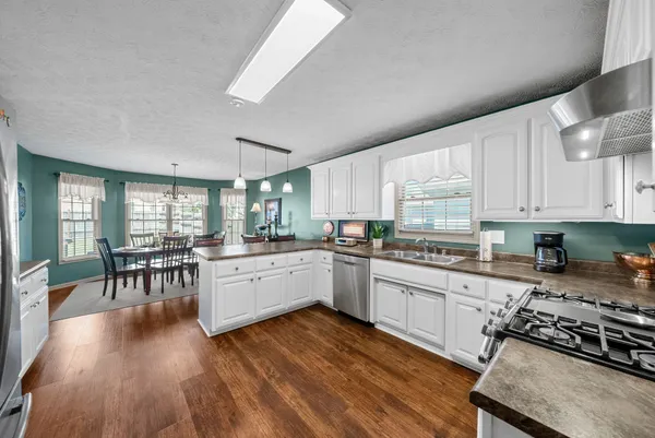 a kitchen with sink stove microwave and cabinets
