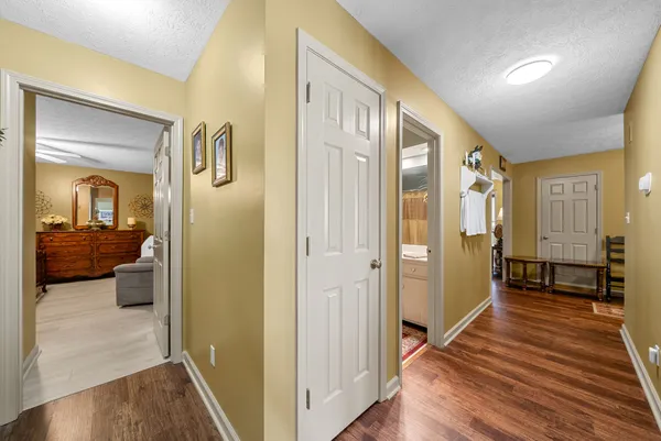 a view of a hallway with bathroom and wooden floor