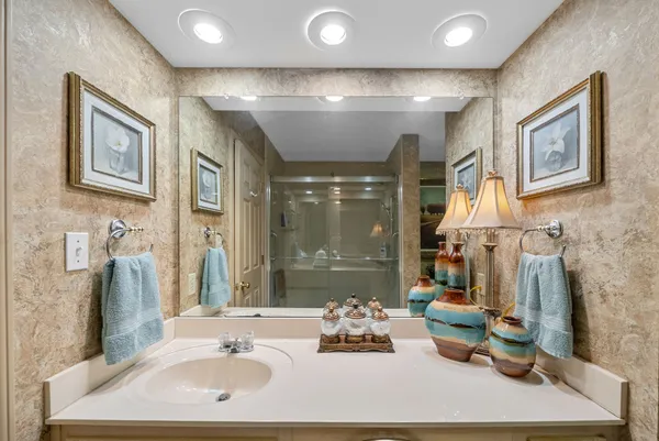 a bathroom with a sink mirror and shower