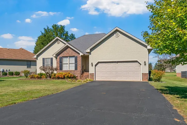 a view of a house with a yard and garage