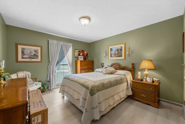 a spacious bedroom with a bed and dresser