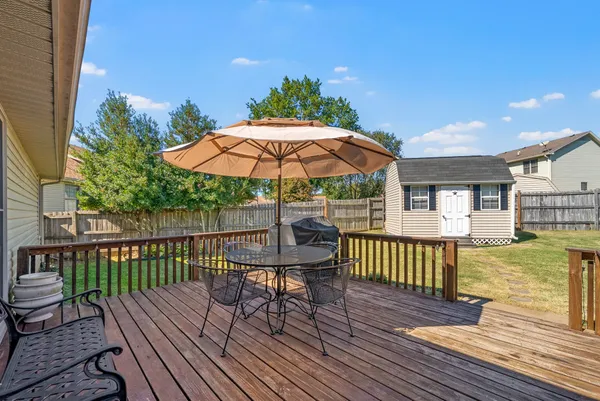 a view of a deck with furniture and umbrella