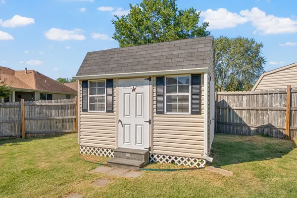 a view of a house with a yard and fence