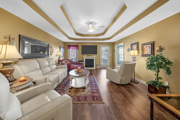 a living room with furniture a flat screen tv and a fireplace