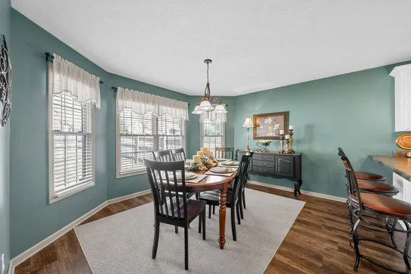 a dining room with furniture a chandelier and wooden floor