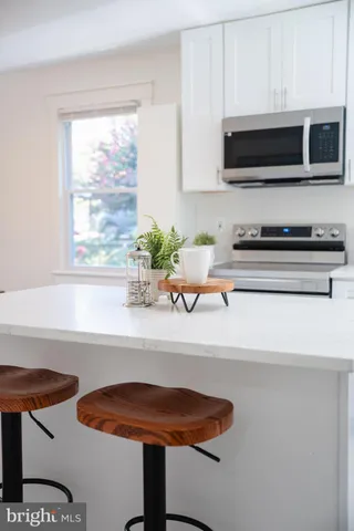 a kitchen with a sink a microwave a stove and cabinets