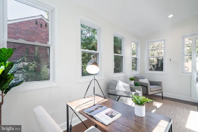 a view of a hallway with wooden floor and cabinet and a bathroom