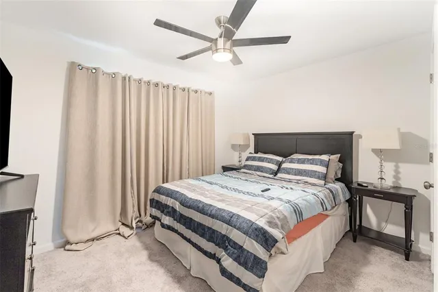 a bedroom with a bed and a ceiling fan