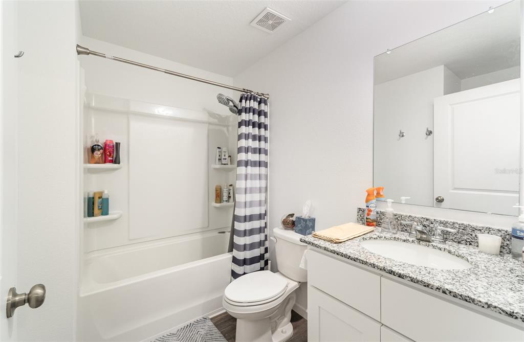 7065 North Heritage Drive Dunnellon, FL 34434 - Photo 19 of 30 a bathroom with a granite countertop sink a toilet and a bathtub