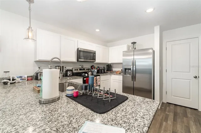 a kitchen with a refrigerator a stove a microwave and cabinets