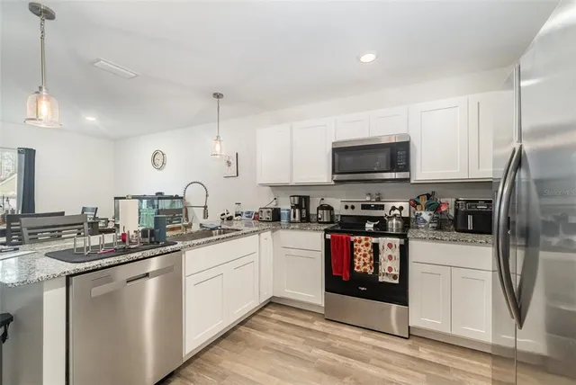 a kitchen with stainless steel appliances granite countertop a sink and a stove