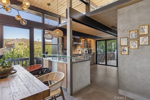 a kitchen with granite countertop a refrigerator and white cabinets