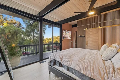 a bedroom with furniture and large windows