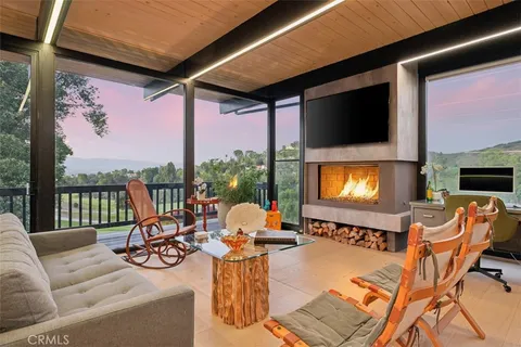 a living room with furniture a flat screen tv and a floor to ceiling window