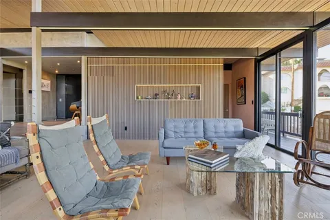 a living room with furniture and a floor to ceiling window