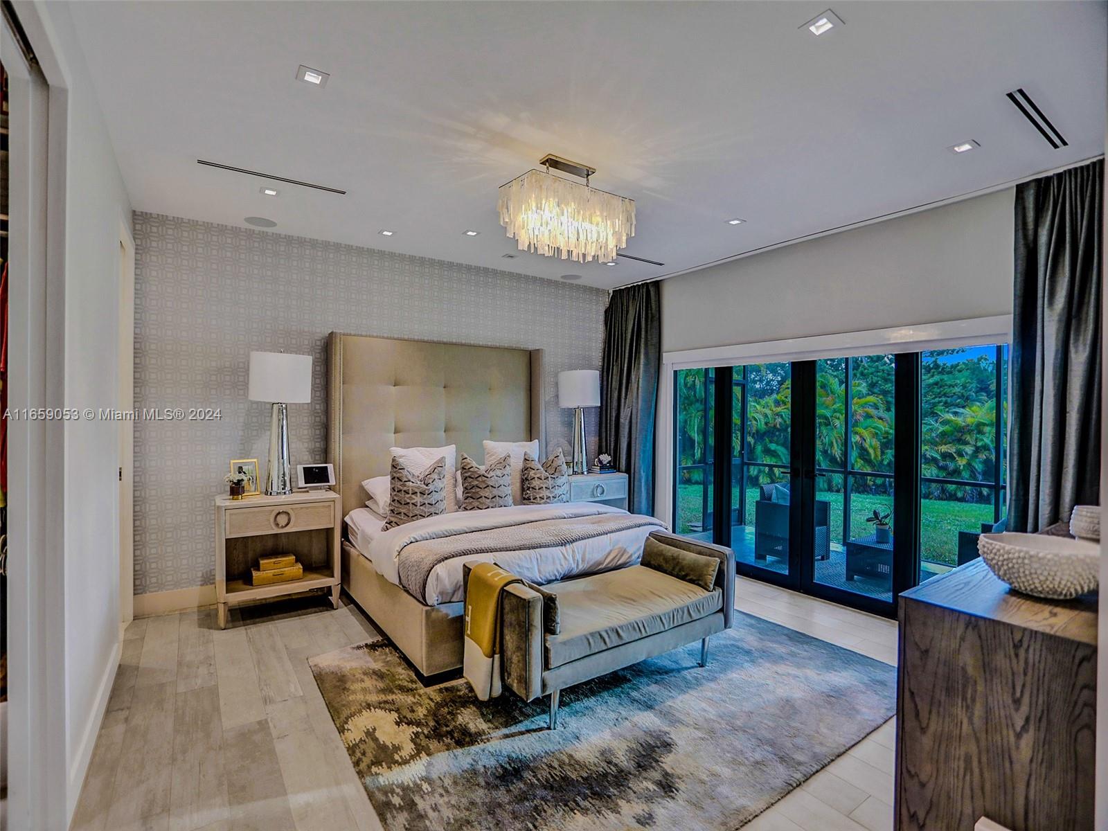20221 Southwest 48th Place Southwest Ranches, FL 33332 - Photo 13 of 42 a bedroom with a large bed and a chandelier