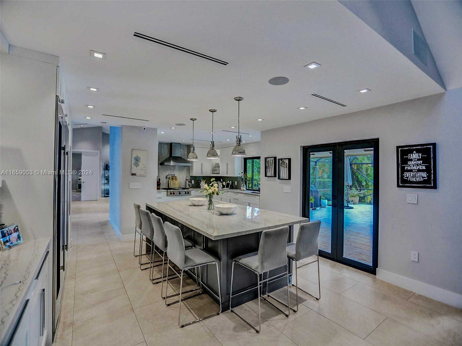 20221 Southwest 48th Place Southwest Ranches, FL 33332 - Photo 22 of 42 a kitchen with stainless steel appliances kitchen island granite countertop a refrigerator a sink a stove and a dining table with wooden floor
