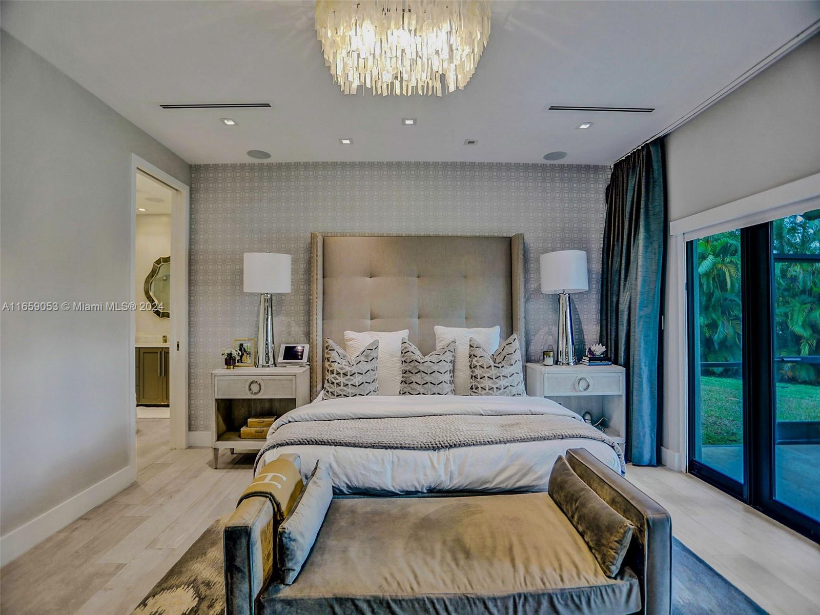 20221 Southwest 48th Place Southwest Ranches, FL 33332 - Photo 26 of 42 a bedroom with a large bed and a chandelier