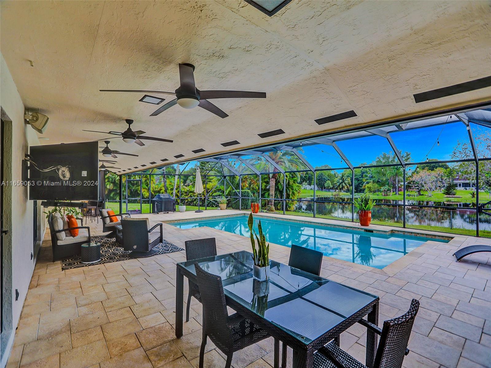 20221 Southwest 48th Place Southwest Ranches, FL 33332 - Photo 36 of 42 a view of a patio with a dining table and chairs under an umbrella